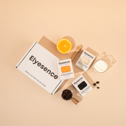 Elyesence Explorer Set with all three signature soaps and natural elements on a peach surface