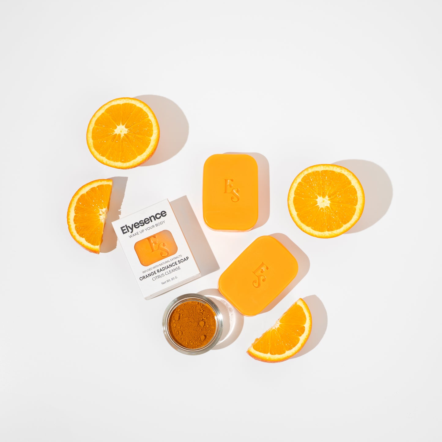 Flatlay of Orange Radiance Soap with turmeric powder and citrus slices on white background